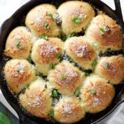 Parmesan Pesto Skillet Rolls | These Parmesan pesto skillet rolls are soft, tender and fluffy, and filled and topped with cheese and pesto. They're perfect to bake and serve as a savory side dish or on their own! Find recipe at redstaryeast.com.