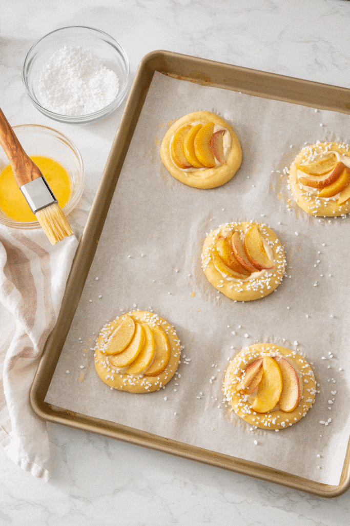 Sprinkling apple tartlets with pearl sugar