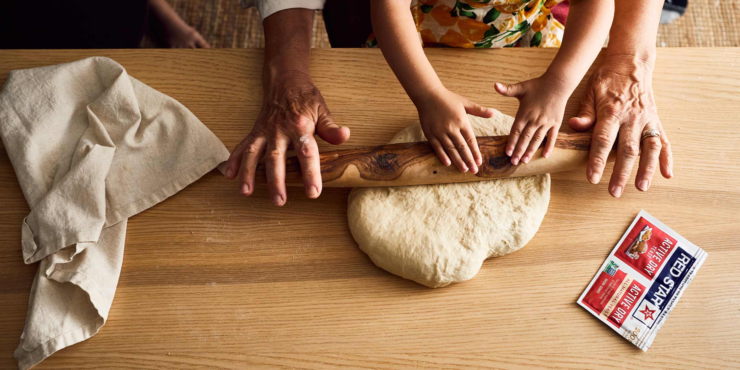 Photo of family members rolling dough together